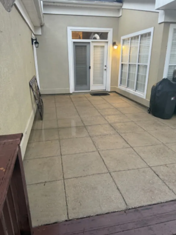 After: residential courtyard patio cleaning, dark buildup removed from the pavers