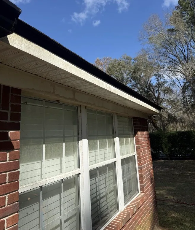 Before: fascia, soffit, and gutter exterior cleaning on a red brick home
