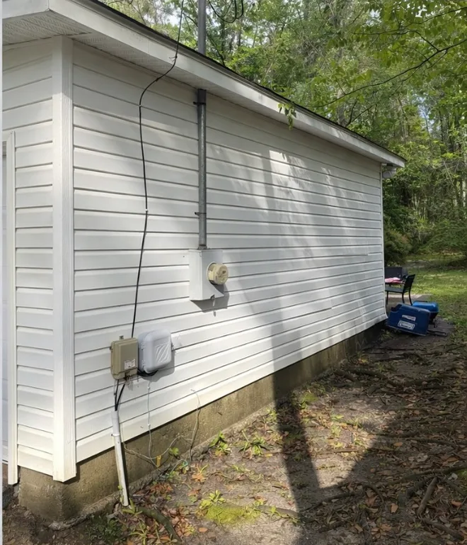 After: house washing on white vinyl siding with green organic growth removed