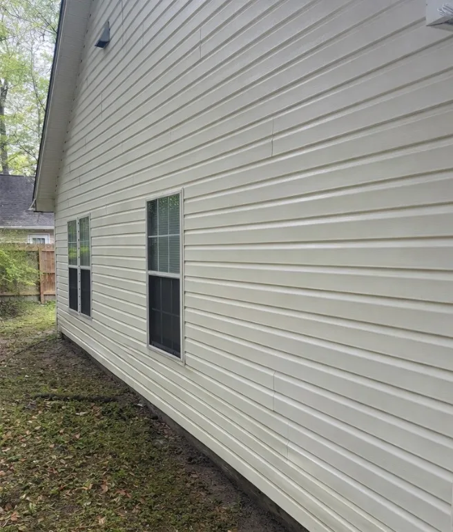 After: house washing on white vinyl siding with green organic growth removed
